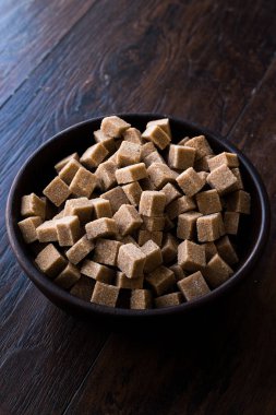 Ham organik kahverengi şeker küpleri içinde ahşap kase yemeye hazır. Gıda ürünleri.