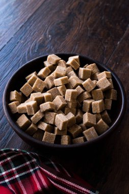 Ham organik kahverengi şeker küpleri içinde ahşap kase yemeye hazır. Gıda ürünleri.