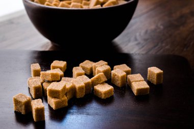 Ham organik kahverengi şeker küpleri içinde ahşap kase yemeye hazır. Gıda ürünleri.