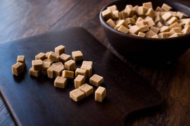 Ham organik kahverengi şeker küpleri içinde ahşap kase yemeye hazır. Gıda ürünleri.