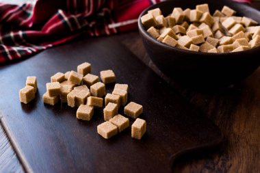 Ham organik kahverengi şeker küpleri içinde ahşap kase yemeye hazır. Gıda ürünleri.