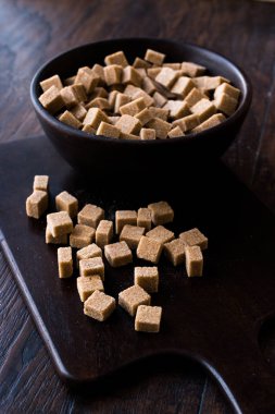 Ham organik kahverengi şeker küpleri içinde ahşap kase yemeye hazır. Gıda ürünleri.