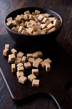 Ham organik kahverengi şeker küpleri içinde ahşap kase yemeye hazır. Gıda ürünleri.