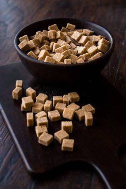 Ham organik kahverengi şeker küpleri içinde ahşap kase yemeye hazır. Gıda ürünleri.