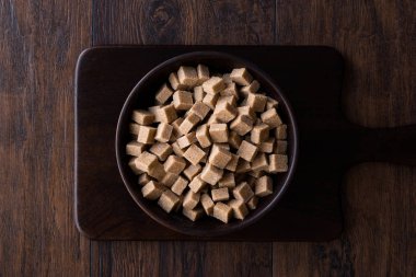 Ham organik kahverengi şeker küpleri içinde ahşap kase yemeye hazır. Gıda ürünleri.