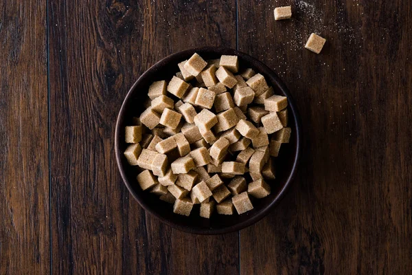Ham organik kahverengi şeker küpleri içinde ahşap kase yemeye hazır. Gıda ürünleri.