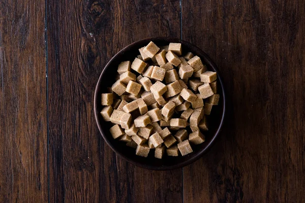 Ham organik kahverengi şeker küpleri içinde ahşap kase yemeye hazır. Gıda ürünleri.