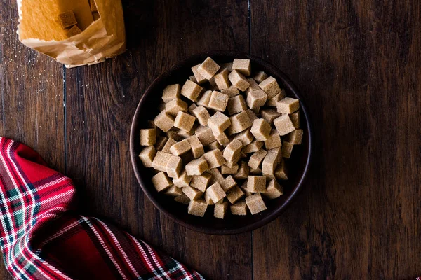 Ham organik kahverengi şeker küpleri içinde ahşap kase yemeye hazır. Gıda ürünleri.