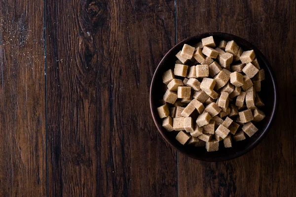 Ham organik kahverengi şeker küpleri içinde ahşap kase yemeye hazır. Gıda ürünleri.