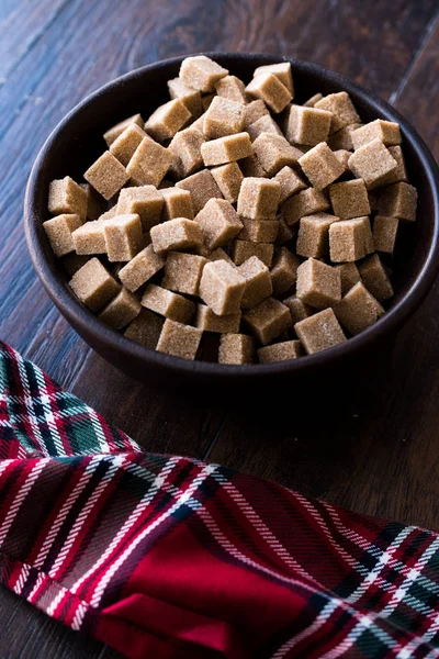 Ham organik kahverengi şeker küpleri içinde ahşap kase yemeye hazır. Gıda ürünleri.