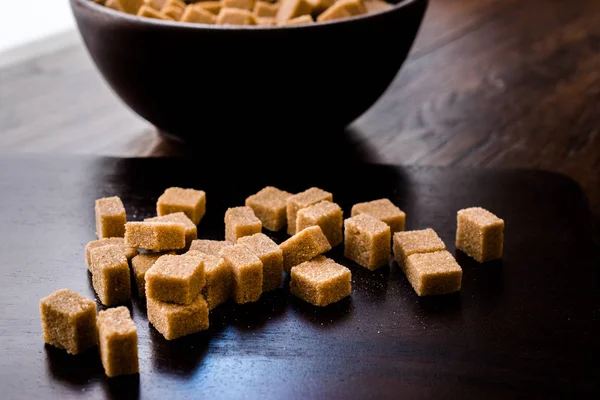 Ham organik kahverengi şeker küpleri içinde ahşap kase yemeye hazır. Gıda ürünleri.