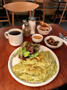 Kahvaltı Pesto omlet, mantar, fıstık ezmesi ve taze filtre tablo / filtre kahve restoranda. Organik gıdalar.