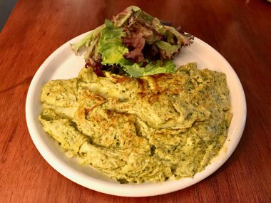 Yeşil omlet Pesto sos ve salata ile Restaurant, hizmet. Kahvaltı için organik gıda.