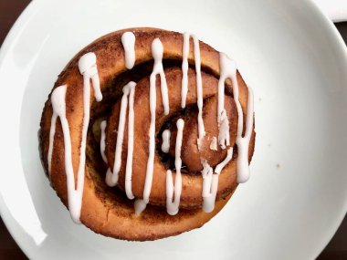 Ev yapımı taze tarçın rulo / topuz krema sosu ile servis Cafe Shop plaka bölümü ile. Ekmek Tatlısı.