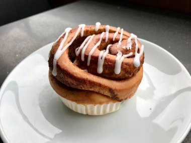 Ev yapımı taze tarçın rulo / topuz krema sosu ile servis Cafe Shop plaka bölümü ile. Ekmek Tatlısı.