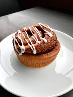 Ev yapımı taze tarçın rulo / topuz krema sosu ile servis Cafe Shop plaka bölümü ile. Ekmek Tatlısı.