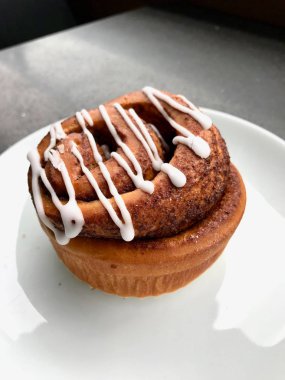 Ev yapımı taze tarçın rulo / topuz krema sosu ile servis Cafe Shop plaka bölümü ile. Ekmek Tatlısı.