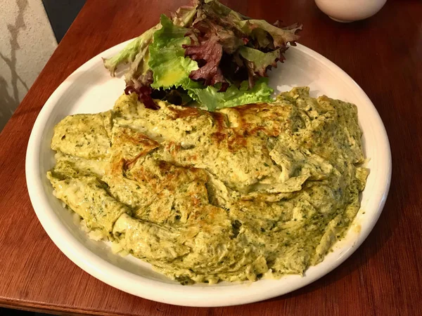 Yeşil omlet Pesto sos ve salata ile Restaurant, hizmet. Kahvaltı için organik gıda.