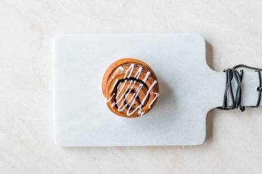 Ev yapımı taze tarçın rulo / topuz krema sosu ile servis mermer kurulu ile. Organik tatlı.