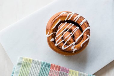 Ev yapımı taze tarçın rulo / topuz krema sosu ile servis mermer kurulu ile. Organik tatlı.