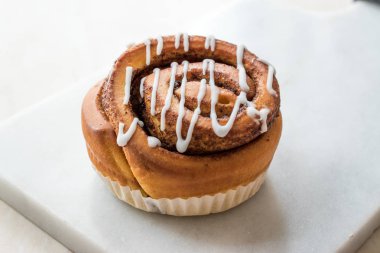 Ev yapımı taze tarçın rulo / topuz krema sosu ile servis mermer kurulu ile. Organik tatlı.