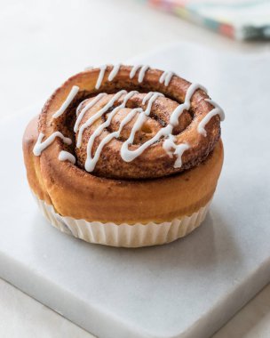 Ev yapımı taze tarçın rulo / topuz krema sosu ile servis mermer kurulu ile. Organik tatlı.