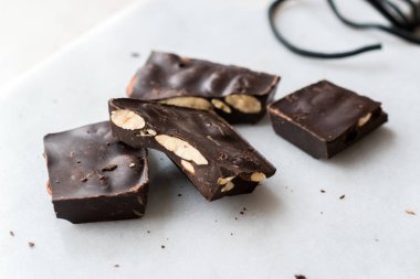 Bitter Almond Chocolate Pieces on White Marble Surface. Organic Snacks.