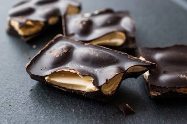 Acı badem çikolata parçaları karanlık mermer yüzey. Organik aperatifler