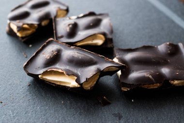 Acı badem çikolata parçaları karanlık mermer yüzey. Organik aperatifler