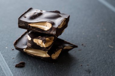 Acı badem çikolata parçaları karanlık mermer yüzey. Organik aperatifler