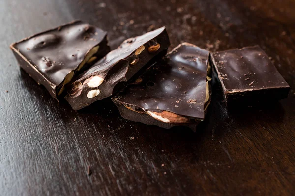 Bitter Almond Chocolate Pieces on Dark Wooden Surface. Organic Snacks.