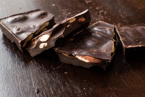 Koyu ahşap yüzey üzerinde acı badem çikolata parçaları. Organik aperatifler.