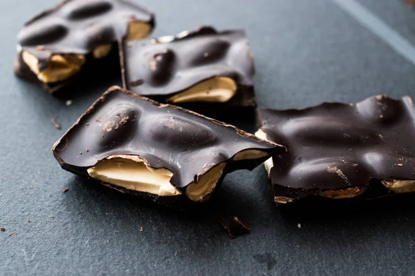 Acı badem çikolata parçaları karanlık mermer yüzey. Organik aperatifler