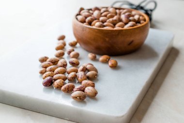 Raw Dry Pinto Beans on Marble Board with Wooden Bowl / Kidney Beans. Organic Food.