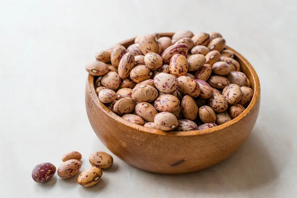 Raw Dry Pinto Beans on Marble Board with Wooden Bowl / Kidney Beans. Organic Food.