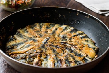 Taze kızarmış sardalyaları / ahşap yüzey üzerinde tavada hamsi kırmızı Tava. Deniz ürünleri