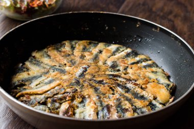 Taze kızarmış sardalyaları / ahşap yüzey üzerinde tavada hamsi kırmızı Tava. Deniz ürünleri