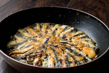 Taze kızarmış sardalyaları / ahşap yüzey üzerinde tavada hamsi kırmızı Tava. Deniz ürünleri