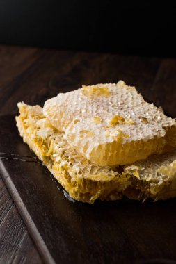 Koyu ahşap tahta üzerinde bal ile taze petek dilimleri. Organik gıda.