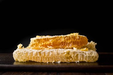 Koyu ahşap tahta üzerinde bal ile taze petek dilimleri. Organik gıda.