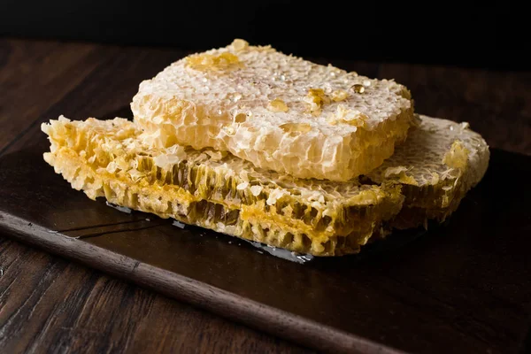 暗い木の板の上に蜂蜜と新鮮なハニカム スライス 有機食品 — ストック写真