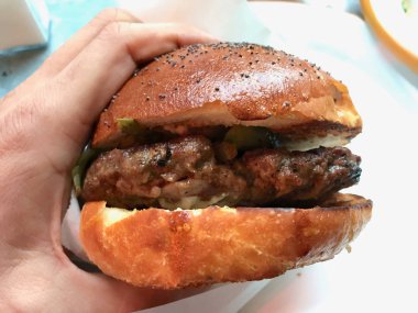 Kuzu eti hamburger kuzu Burger tutan el ile aradı. Fast Food.