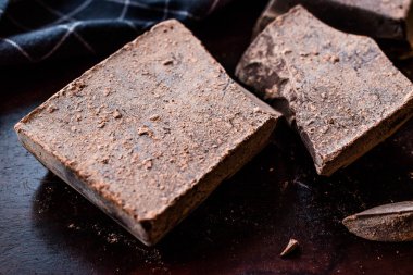 Koyu ahşap yüzeyde Kuvertür Bitter çikolata parçaları. Organik gıda.