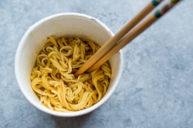 Anlık köri aromalı Ramen erişte yemek çubukları ile servis. Plastik kap içinde. Geleneksel Fast Food.