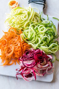 Sebze erişte havuç, kırmızı pancar, kabak ve salatalık mermer gemide spiralized. Organik gıda.
