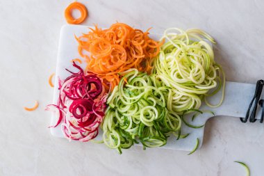 Sebze erişte havuç, kırmızı pancar, kabak ve salatalık mermer gemide spiralized. Organik gıda.