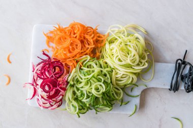 Sebze erişte havuç, kırmızı pancar, kabak ve salatalık mermer gemide spiralized. Organik gıda.