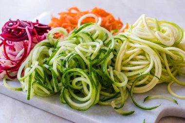 Sebze erişte havuç, kırmızı pancar, kabak ve salatalık mermer gemide spiralized. Organik gıda.