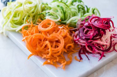 Sebze erişte havuç, kırmızı pancar, kabak ve salatalık mermer gemide spiralized. Organik gıda.