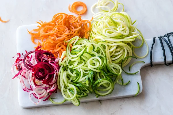 Sebze erişte havuç, kırmızı pancar, kabak ve salatalık mermer gemide spiralized. Organik gıda.